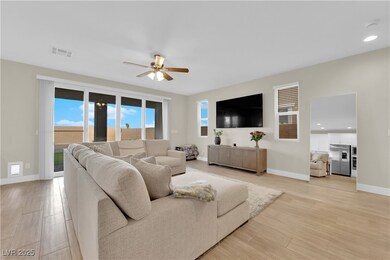 Living room with a ceiling fan, visible vents, bas