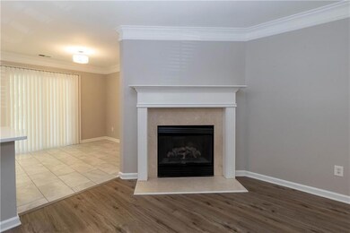 Detailed view of ornamental molding, a fireplace with raised hearth, and wood finished floors