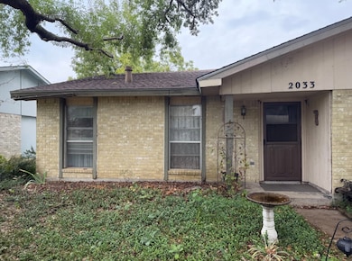Property entrance with brick siding and roof with shingles