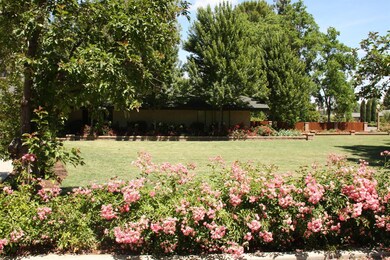 Large expanse of lawn in front, with flower beds b