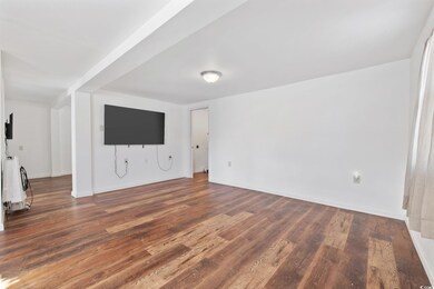 Unfurnished living room featuring dark hardwood / 