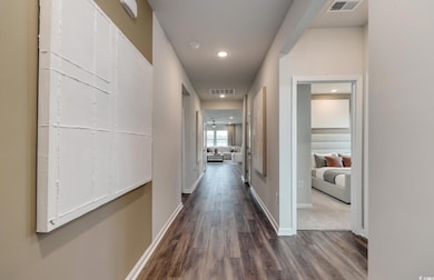 Hallway featuring baseboards, visible vents, reces