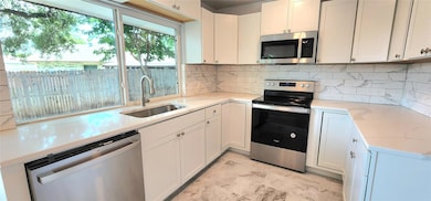 Kitchen featuring tasteful backsplash, light tile 
