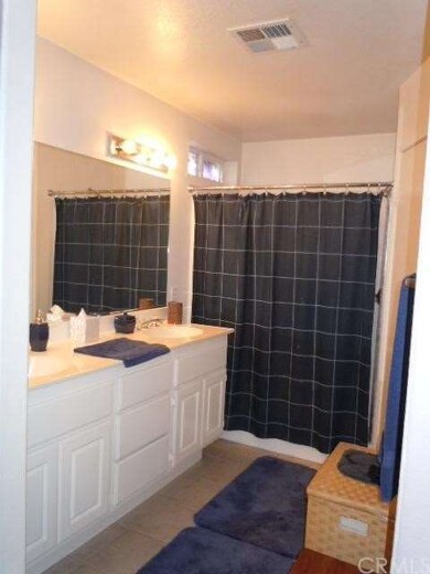 Master bath has double sinks and tile flooring.