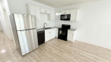 Kitchen featuring light stone countertops, white c