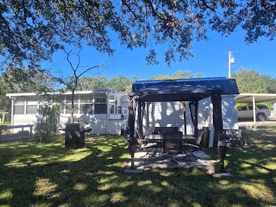 Dock area with a gazebo, a yard, and a patio