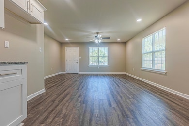 Unfurnished living room featuring ceiling fan and 