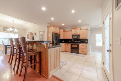 Large eat-in kitchen with raised countertop supporting 3-4 bar stools.