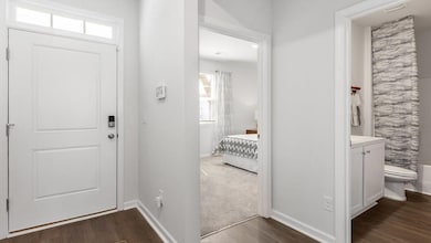 Foyer featuring dark wood-style floors and baseboards