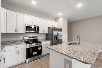 Kitchen featuring a kitchen island with sink, ligh