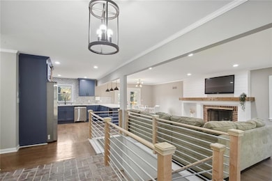 Kitchen with a brick fireplace, tasteful backsplash, hanging light fixtures, appliances with stainless steel finishes, and blue cabinets