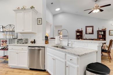 Kitchen with lofted ceiling, sink, dishwasher, lig