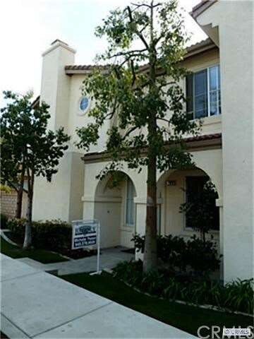 Front building view with full grown trees.
