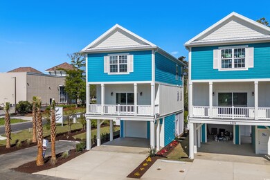 Coastal inspired home with a garage, a carport, and driveway
