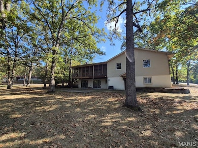 Back of house with a sunroom and a deck