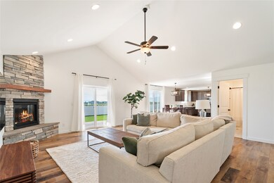 Living area featuring wood-type flooring, high vaulted ceiling, ceiling fan, a fireplace, and recessed lighting