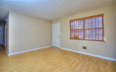 Empty room with wood finished floors, baseboards, and a textured ceiling