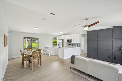 Living room featuring lofted ceiling, ceiling fan,