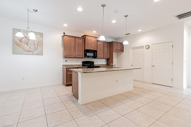 Kitchen featuring black appliances, a sink, light 
