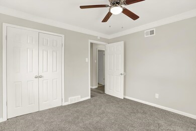 Unfurnished bedroom featuring carpet, baseboards, a closet, a ceiling fan, and ornamental molding