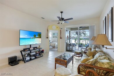 Living room featuring ceiling fan and light tile p