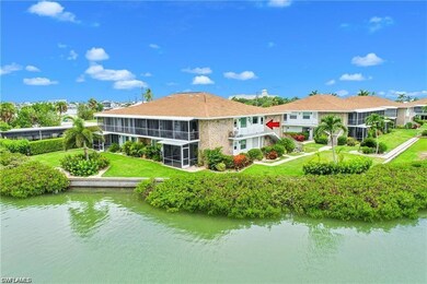 Rear view of property featuring a water view, a sunroom, and a lawn