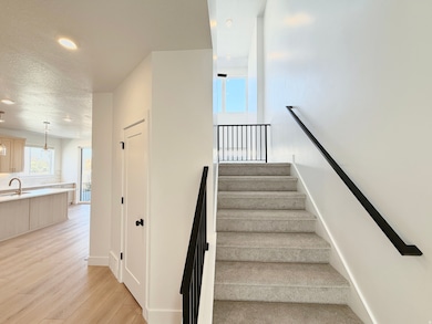 Staircase featuring plenty of natural light, wood finished floors, recessed lighting, and a textured ceiling