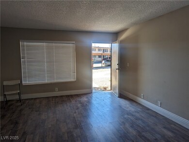 Spare room with a textured ceiling, baseboards, an