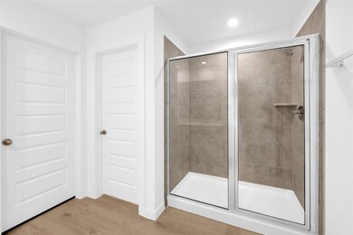 Massive Seamless Glass Shower for Two! Never have to wait for the Water to Get Hot after someone takes a shower due to the Tankless/On-Demand H2O Heater your will never run out of Hot Water!!Image is of the Model Home and is a Representative of the Plan being Built**