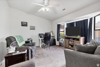 Carpeted office space featuring plenty of natural light and a ceiling fan