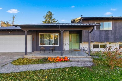 View of front of property with brick siding, a porch, a garage, and concrete driveway