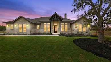 View of front of house featuring a chimney, stone