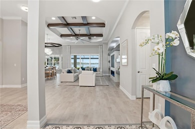 Entryway with coffered ceiling, ornamental molding, beam ceiling, light wood-style flooring, and ceiling fan