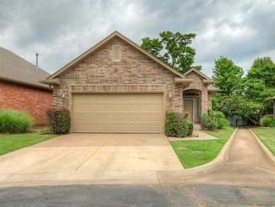 Traditional-style home featuring brick siding, concrete driveway, and a garage