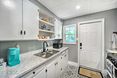 Kitchen with gas stove, black microwave, open she