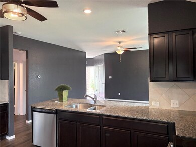 Kitchen with light stone countertops, a sink, cei