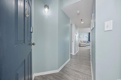 Hall featuring a textured ceiling, wood finished f