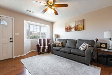 Living room featuring hardwood / wood-style floors, a textured ceiling, and ceiling fan