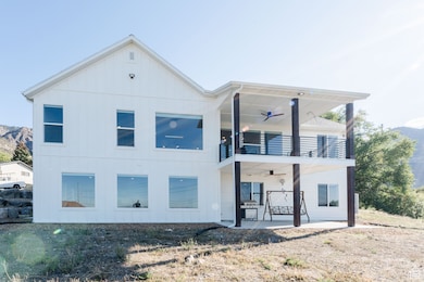 Back of property featuring a patio, ceiling fan, and a mountain view