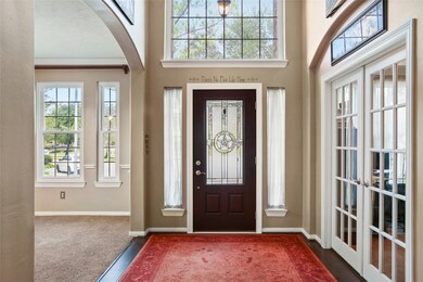 An impressive entry welcomes all who enter. You'll immediately notice the beautiful flooring, elegant lighting, Frech doors, soaring ceiling, arched doorways, decorator paint and gorgeous natural light.