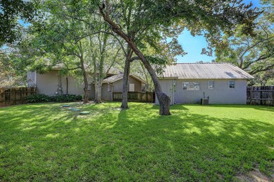Partially fenced in yard behind the primary home and workshop