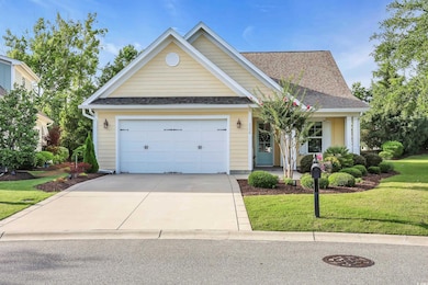 Traditional-style home with driveway, a front lawn, a shingled roof, an attached garage, and covered porch