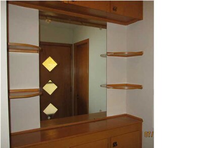 The entryway has a display buffet and a large coat