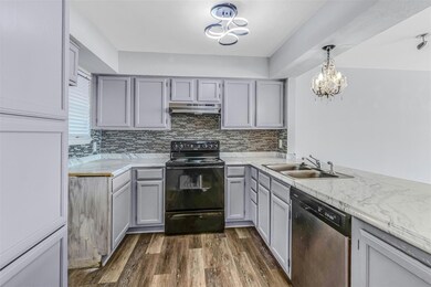 Kitchen with stainless steel dishwasher, dark wood