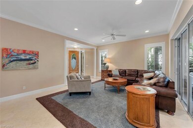 Living room featuring crown molding, light tile pa