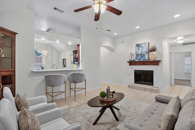 A bright living space highlighted by a cozy fireplace with decorative mantle.