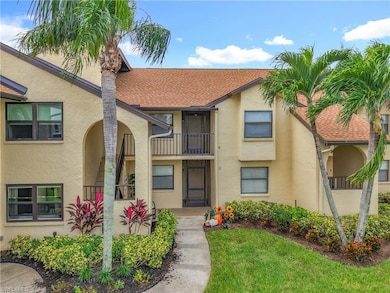 View of front of home with a balcony, stucco siding, roof with shingles, and a front yard
