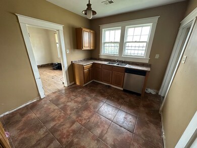 Kitchen featuring dishwasher, dark tile patterned 