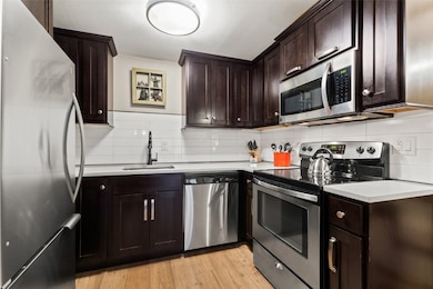 Kitchen with tasteful backsplash, light wood floor