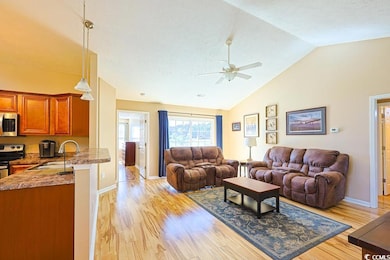 Living area with light wood finished floors, ceiling fan, and high vaulted ceiling